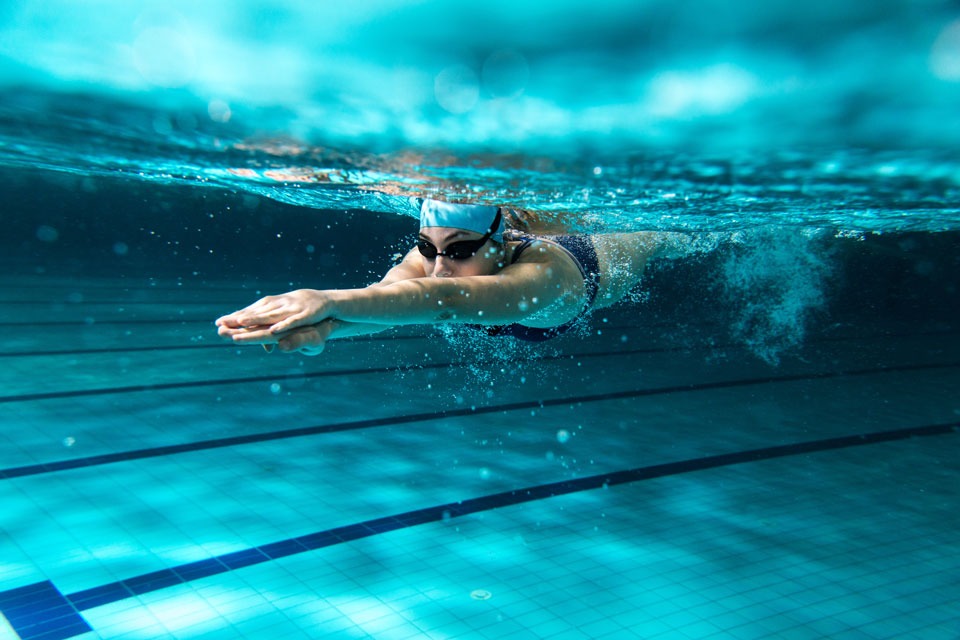 femme natation avec des protections auditives